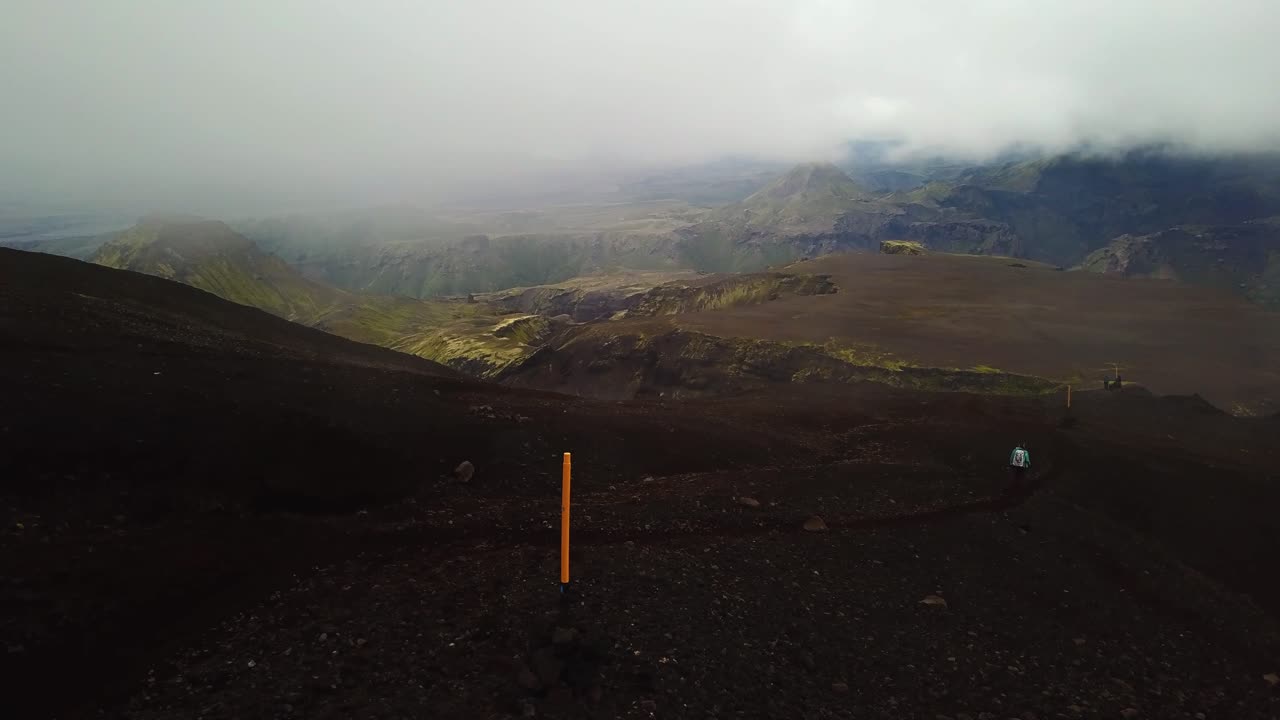 vista aérea del paisaje de una persona caminando por un sendero de montaña, en un día nublado, en el área de fimmvörðuháls, islandia