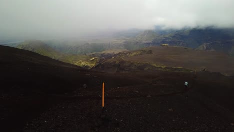 Aerial-landscape-view-of-a-person-hiking-on-a-mountain-trail,-on-a-foggy-day,-in-Fimmvörðuháls-area,-Iceland