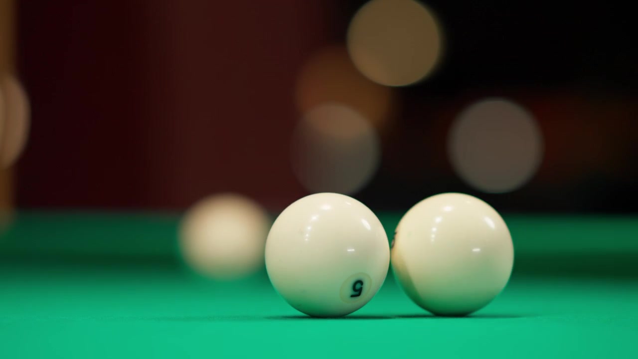 White Billiard Balls Rolling and Colliding on Green Felt