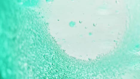 macro shot of many small blue bubbles sparkling in water with a bright background