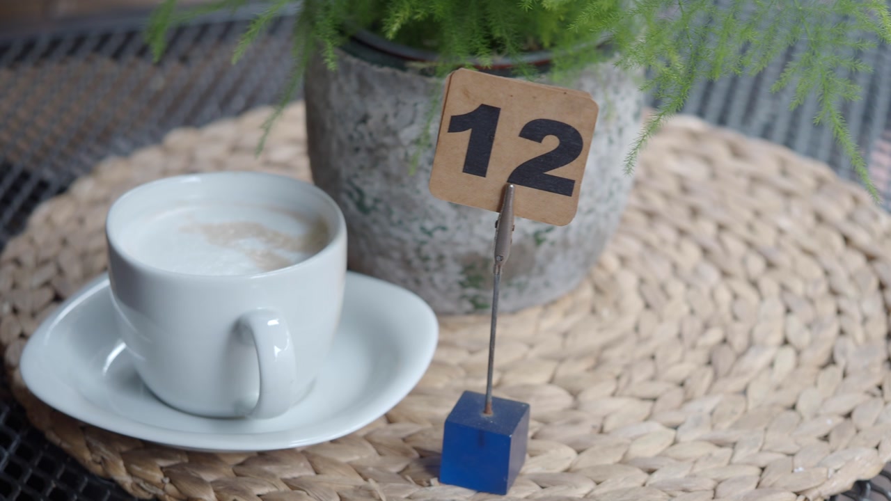 Close-up of Coffee Cup and Table Number 12 at an Outdoor Cafe