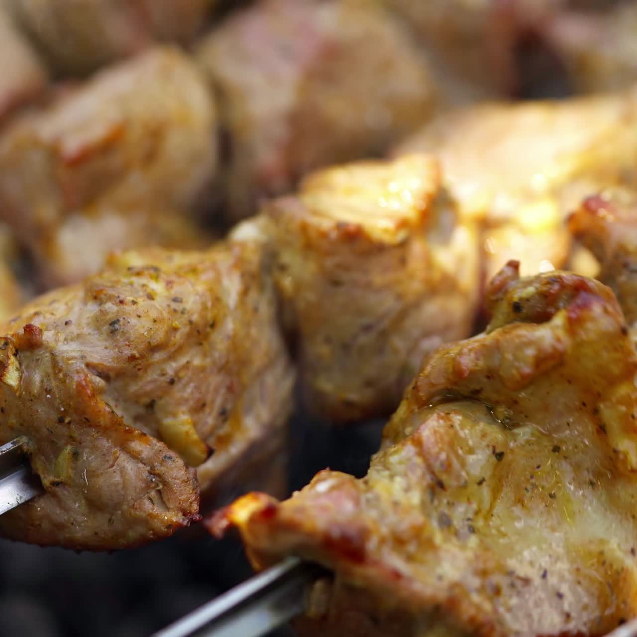 Barbecue cooking. Meat roasts on fire. Tasty pork on skewers on grill. Kebab. Delicious food. Close-up.