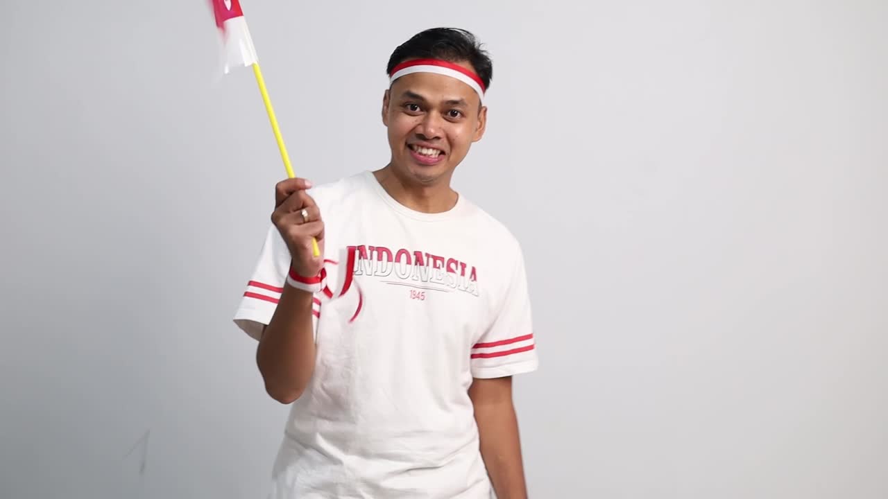 Indonesian man standing holding red white flag to celebrates Indonesia independence day