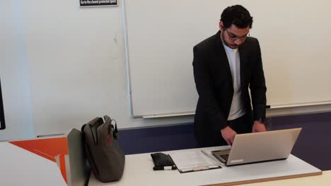 university professor setting up laptop before class