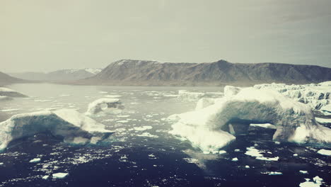 montañas nevadas y icebergs a la deriva en el mar de groenlandia