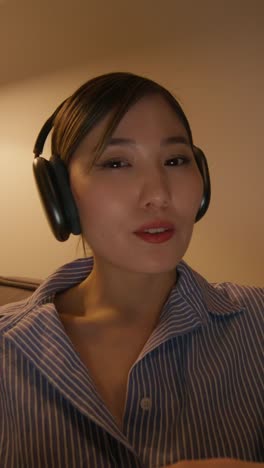 woman wearing headphones, likely in a video call