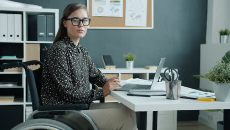 woman in wheelchair working in modern office