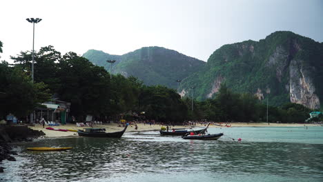 boats and tourists on the shore of phi phi islands in krabi, thailand