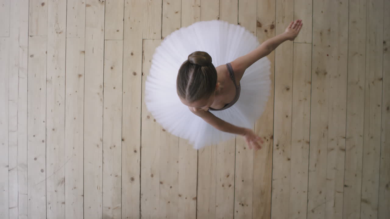 Top View Of Graceful Little Ballerina Dancing In Studio