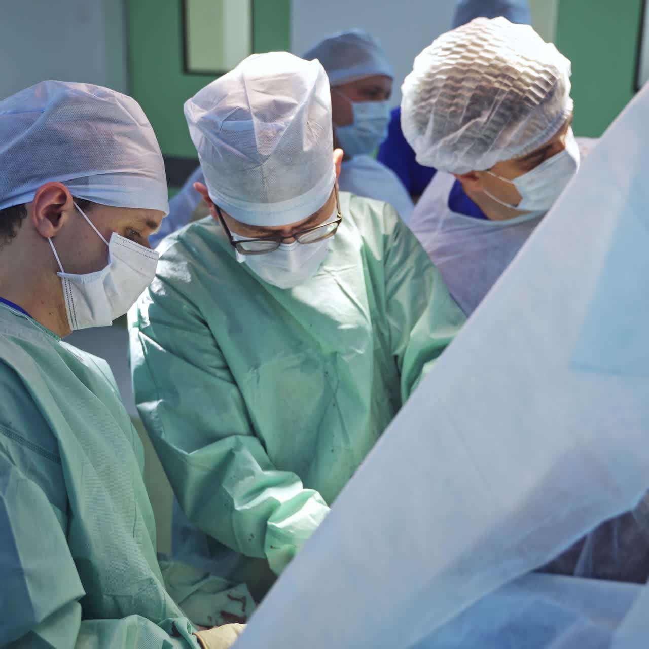 Group of three surgeons work hard at operation. Many professionals gathered in operational theater for hard case surgery