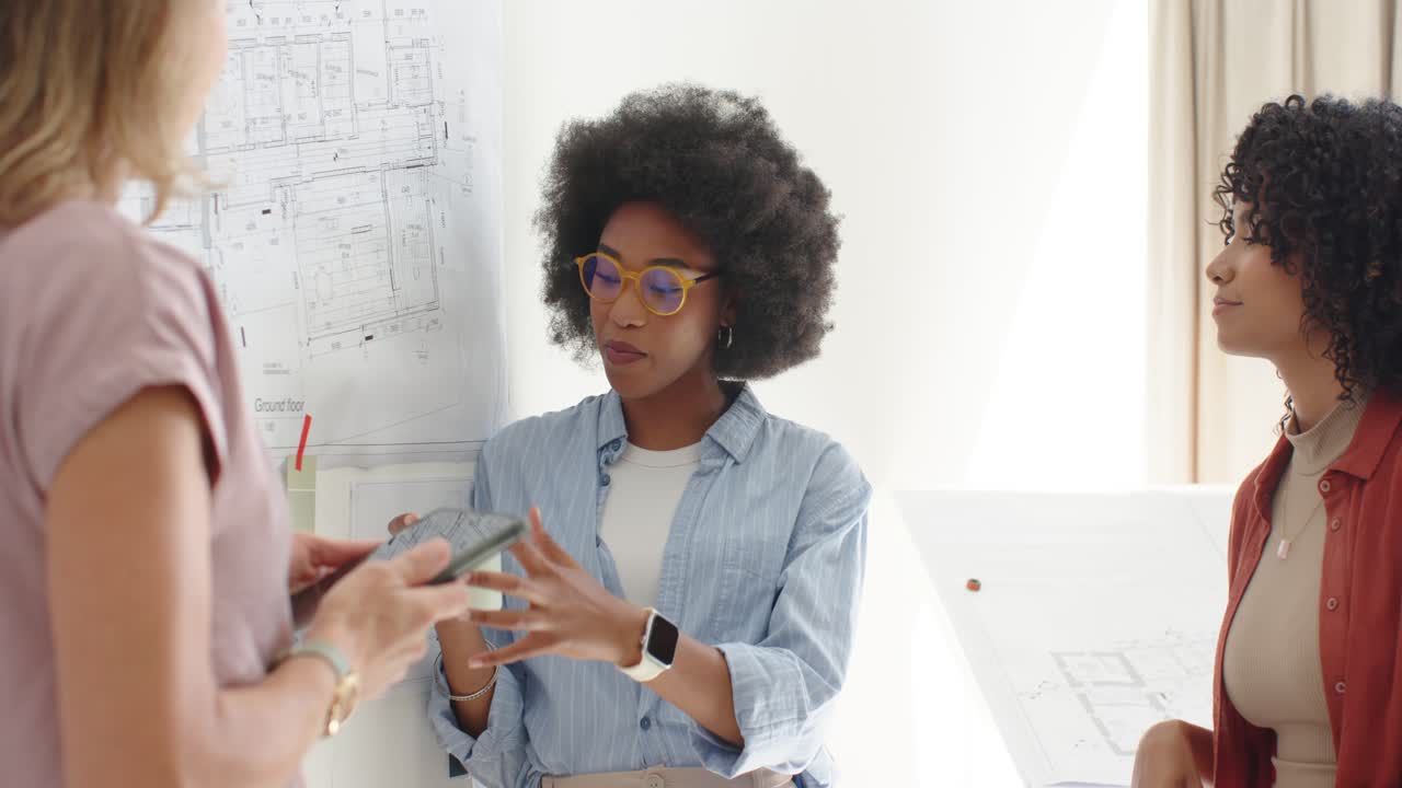 Team watching African American woman leading plans review after blonde showing phone, gesturing mug