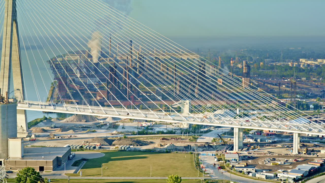 Aerial view highlighting the Gordie Howe Bridge with industrial scenery in the distance