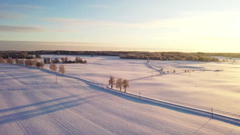 country side road during cold snowy winter season, golden sunset, aerial drone shot