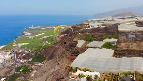 Paraglider-flying-on-a-cliff-on-next-to-the-Ocean-filmed-by-a-Drone