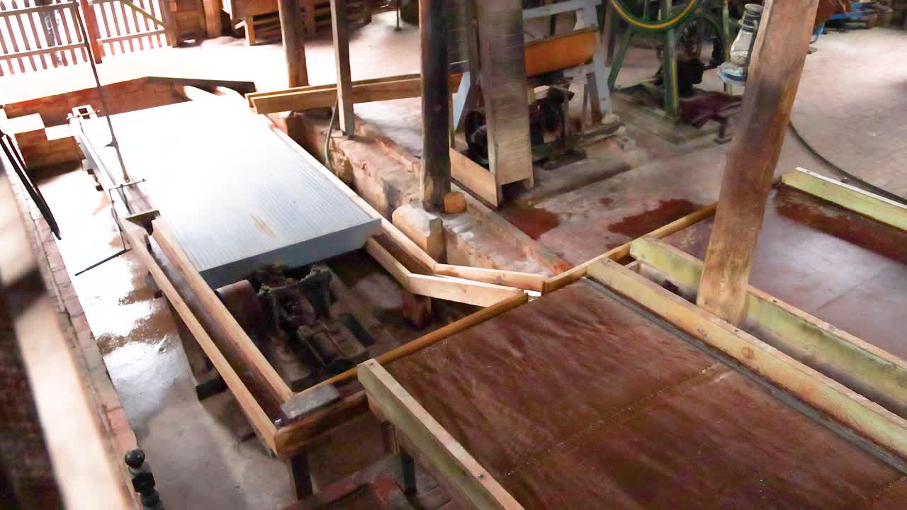 un aserradero tradicional en ballarat, australia, procesa la madera usando un mecanismo impulsado por el viento. la luz natural destaca las máquinas de madera