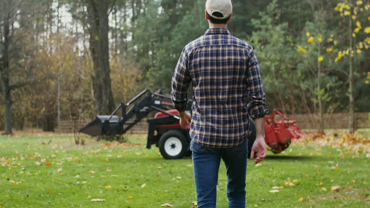 에서 트랙터 를 보고 있는 농부