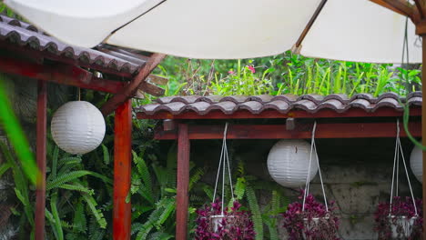 raindrops grace a wooden roof and lantern in a garden oasis, captured in slow motion