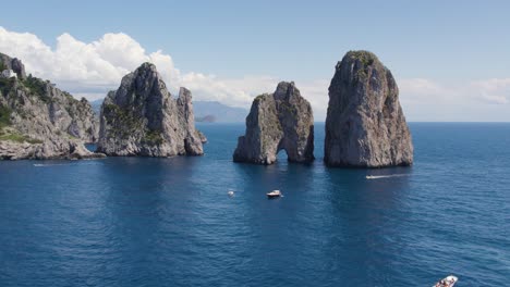 faraglioni rock sea stacks on coast of capri island, italy - aerial