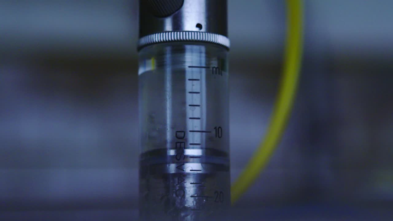 Fluid inside transparent tube moves up and down as device activates in lab