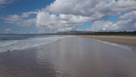 adelante aéreo a baja altitud sobre una playa desierta con olas rompiendo en la costa, soustons en francia