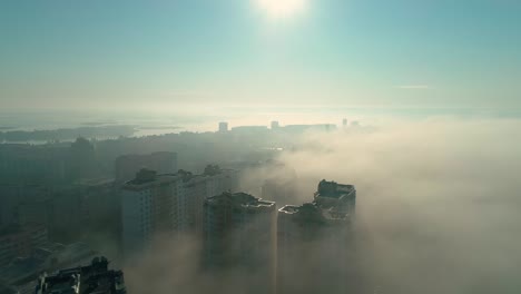 aerial drone footage of flying over the city in fog during dawn