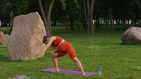mujer embarazada practicando yoga en un parque
