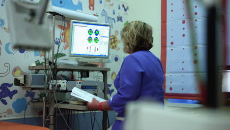 Ärztin-Bei-Der-Arbeit-In-Einem-Krankenhaus,-Schaut-Auf-Ihren-Monitor-Und-Führt-Analysen-Durch