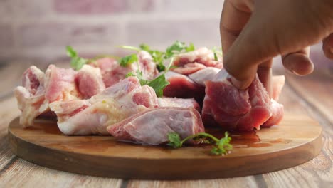 carne cruda cortada en una tabla de cortar de madera con hierbas