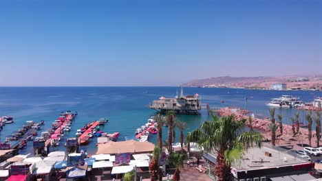 scenic view of a bustling coastal resort with a marina, boats, and palm trees