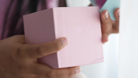 woman opening a pink gift box