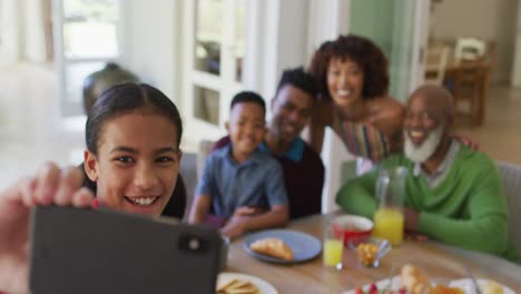 Afroamerikanisches-Mädchen,-Das-Ein-Selfie-Macht,-Während-Es-Mit-Seiner-Familie-Zu-Hause-Frühstückt