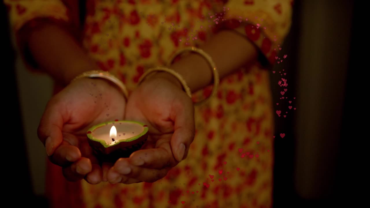 Woman holding lit diya, offering palms, starting heart dots rising, forming, fading for marketing