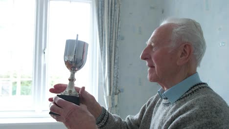 senior caucasian man inspecting his trophy