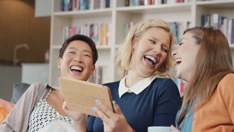 friends at home using digital tablet for social media having fun laughing
