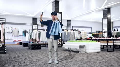 man taking selfie in shopping mall with shopping bags