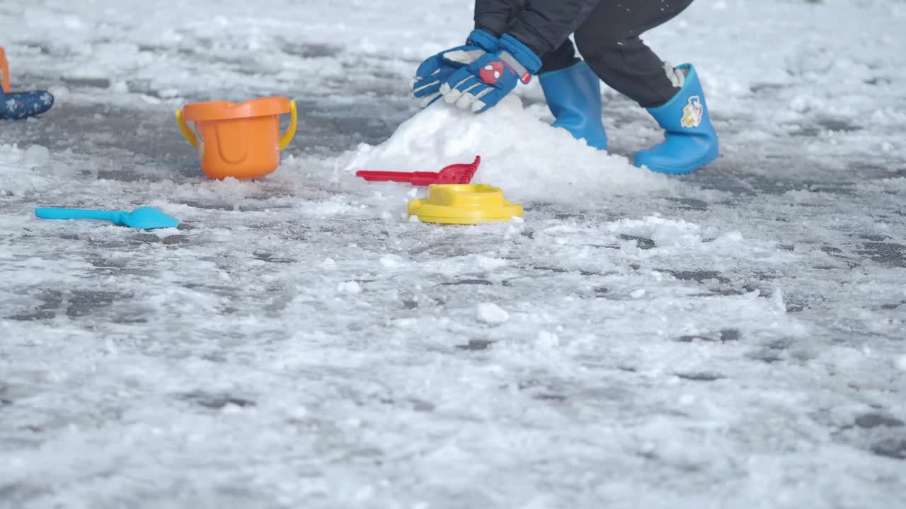 Children playing in the snow with colorful toys