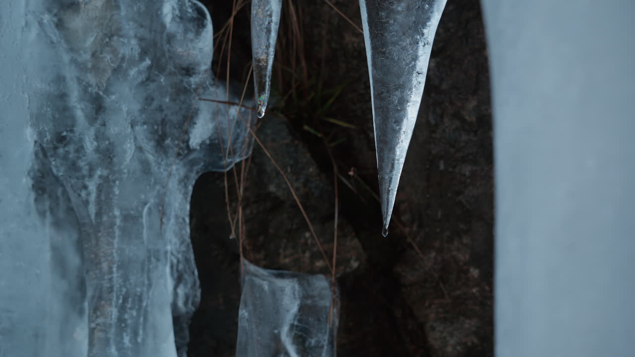 Primo piano di ghiaccio che si scioglie e goccia d'acqua che cade dalla punta del ghiaccio in una giornata invernale in Norvegia