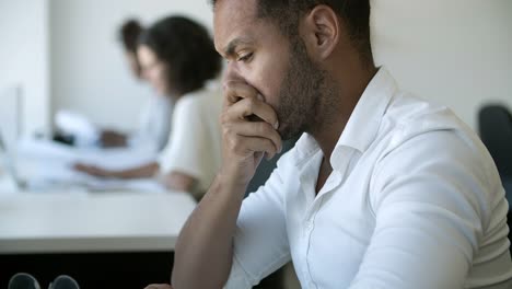 Exhausted-African-American-man-looking-at-laptop