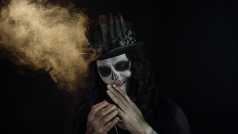 hombre espeluznante con maquillaje de esqueleto en sombrero de copa. tipo haciendo caras, sonrisa dentada. fiesta temática de halloween