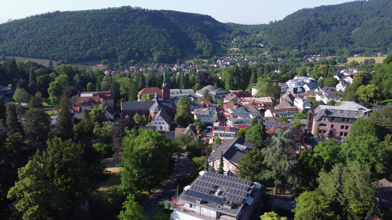 Spa town of Badenweiler in lush forested countryside, aerial trucking shot
