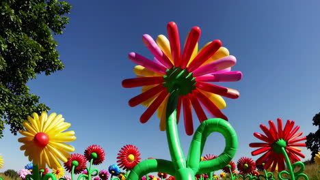 field of colorful inflatable flowers under a blue sky