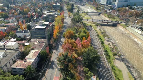 Aerial-Drone-fly-autumnal-riverside-traffic-landscape-of-Santiago-de-Chile-city-green-colorful-park