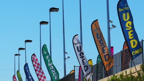 Colorful-advertising-pennants-flapping-in-a-strong-breeze-against-clear-blue-sky