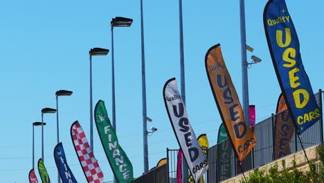 colorful advertising pennants flapping in a strong breeze against clear blue sky