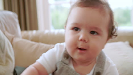 happy baby boy playing on sofa at home