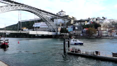 white boat crossing majestic antique luis i bridge in porto, portugal, day