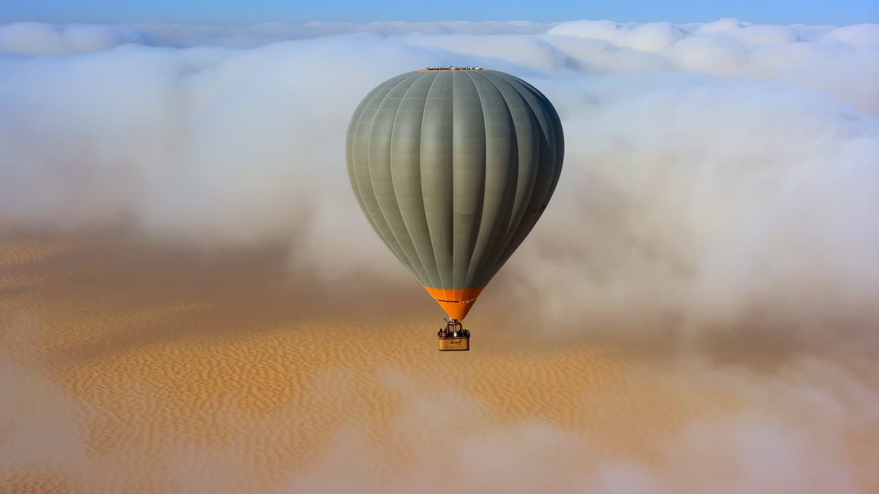 Hot Air Balloon Soaring Above Desert Dunes and Clouds