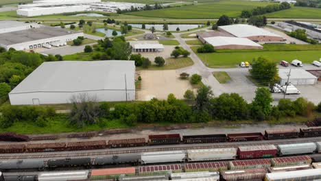 4k aerial reveal of multiple trains as they are stationary at a train station
