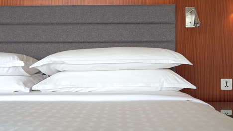 Close-up-pan-across-the-neatly-stacked-pillows-on-a-hotel-suite-bed