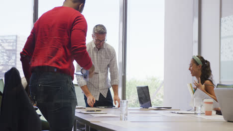 Diverse-male-and-female-business-colleagues-discussing-at-meeting